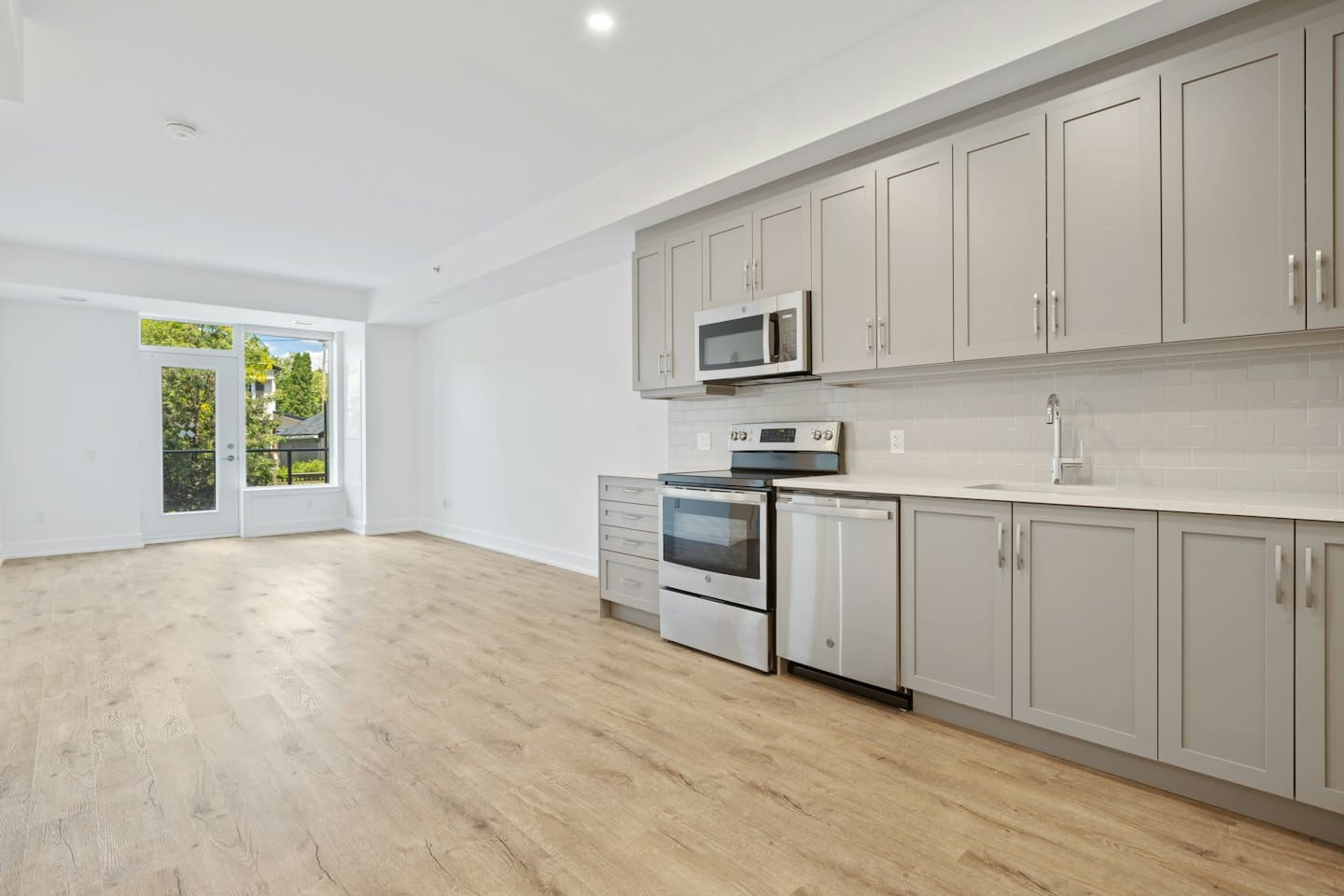 Appartamento moderno non arredato con cucina e balcone.